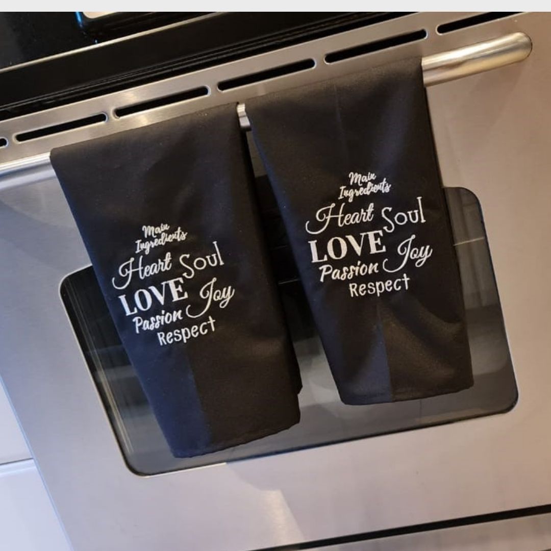 Set de 2 Mantas de Cocina Negras con Mensaje Inspirador